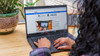 Refurbished A person using a Dell Latitude 5400 i5 laptop on a wooden surface, with their hands positioned near the keyboard and screen,