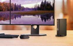 Refurbished Dell mini desktop computer with Intel Core i3 processor and 4GB RAM, positioned on a wooden desk with a landscape...